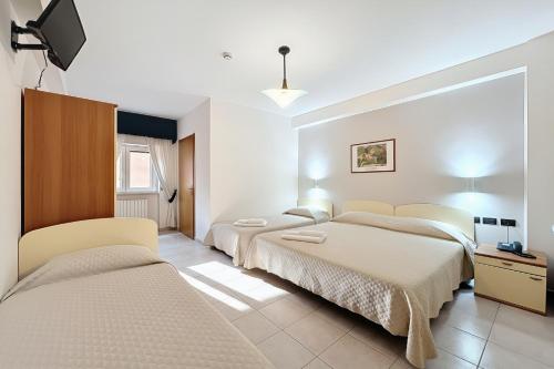 a bedroom with two beds and a flat screen tv at Santangelo in Monte SantʼAngelo