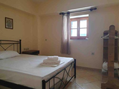 a bedroom with a bed and a window at Emma's studio house by Kapsali beach in Kapsali