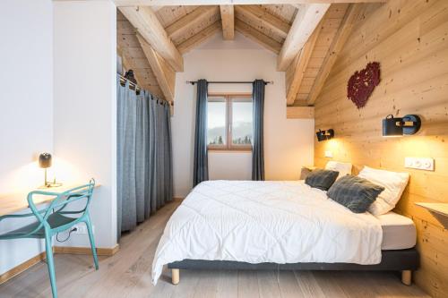 a bedroom with a white bed and a blue chair at Germain Ski Lodge in La Toussuire