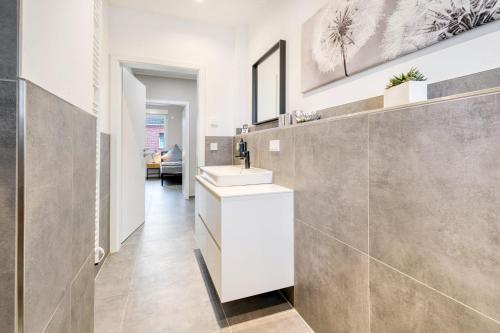 a bathroom with a white sink and a mirror at Stadtquartier Ahaus in Ahaus