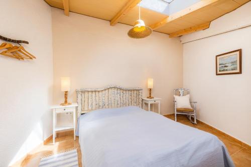 a bedroom with a bed and two tables and a chair at Apartment Adults Only - Mallorca in Manacor