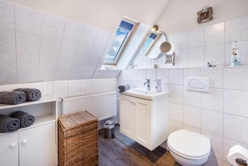 a white bathroom with a toilet and a sink at Ferienwohnung Lemburg in Nindorf