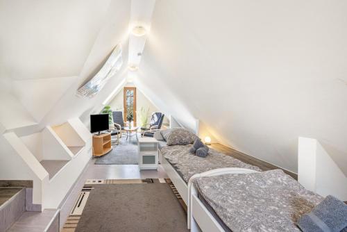 a attic bedroom with two beds and a tv at Ferienwohnung Lemburg in Nindorf