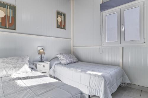 a white bedroom with two beds and a cabinet at El encanto de Ronda in Ronda