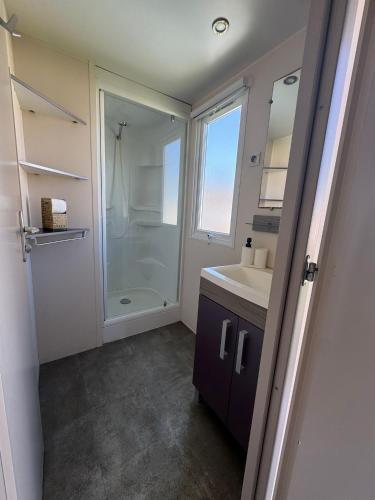 a bathroom with a shower and a sink and a mirror at Coral Bungalow in Ayamonte