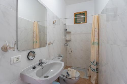 a bathroom with a sink and a toilet and a mirror at Apartamento Nayara D in Valle Gran Rey