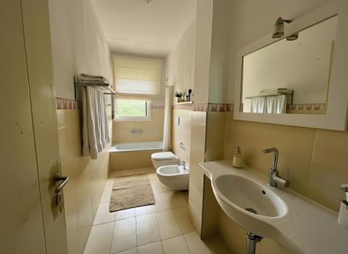 a bathroom with a sink and a toilet and a mirror at Apartment Simone in Baja Sardinia