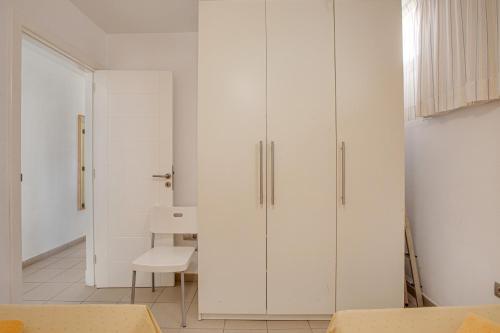 a room with white cabinets and a white chair at Casa Médano 18 in Granadilla de Abona