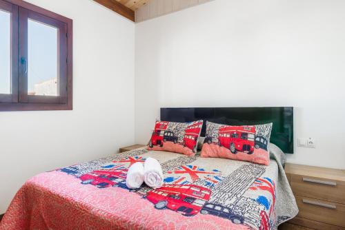 a bedroom with a bed with a blanket and pillows at Casa Hefestión in Conil de la Frontera