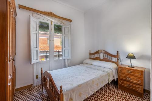 a bedroom with a bed and a window and a dresser at Casa Adriana con piscina in Murchas