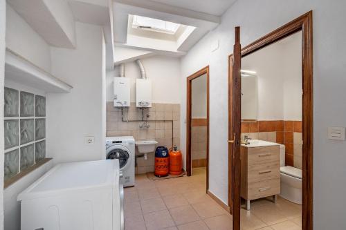 a bathroom with a sink and a washer and dryer at Casa Adriana con piscina in Murchas
