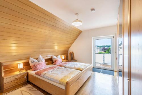 a bedroom with a bed and a large window at Ferienhaus Soonwald Liebe in Seesbach