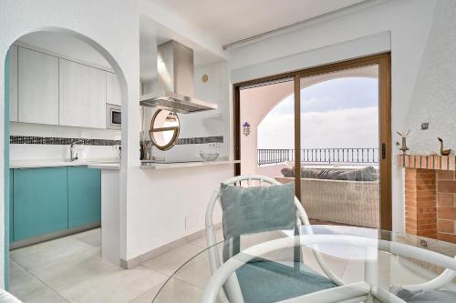 a kitchen with a glass table and a view of the ocean at Atalaya in Almuñécar