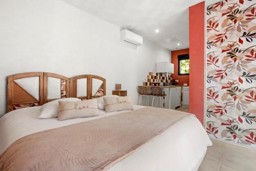 a bedroom with a large bed and a kitchen at Les Gîtes W elles come in Cotignac