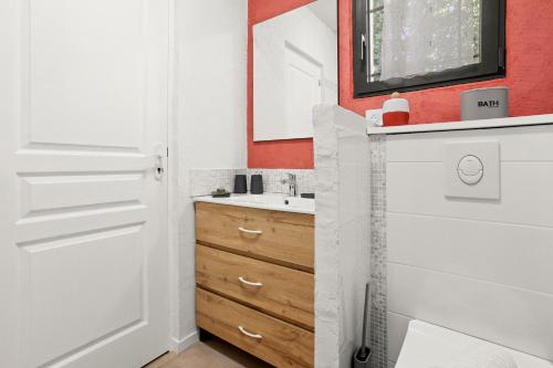 a bathroom with a white door and a sink at Les Gîtes W elles come in Cotignac