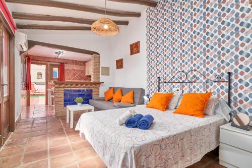 a bedroom with a bed with orange pillows and a couch at Estudio Quorum, centro de Nerja in Nerja