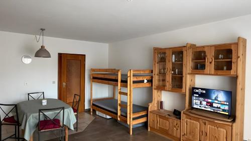 a living room with a bunk bed and a television at Ferienwohnung Voges mit Pool in Bad Lauterberg