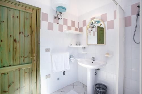 a bathroom with a sink and a mirror at mirtagru appartamento dell'oleandro in Budoni