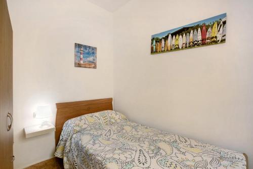 a small bedroom with a bed and two pictures on the wall at Las Arenas Medio in La Mareta