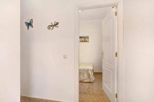 a hallway with a door leading to a room with a bed at Las Arenas Medio in La Mareta