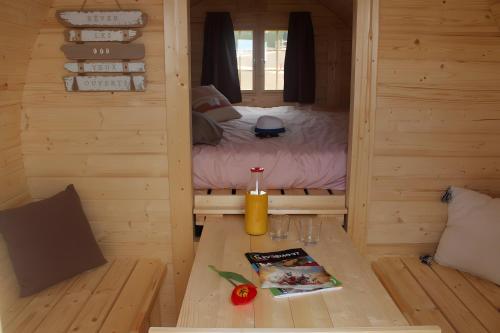 a small room with a bed and a table in a cabin at Barrel Papilles En Escapade in Sevremont
