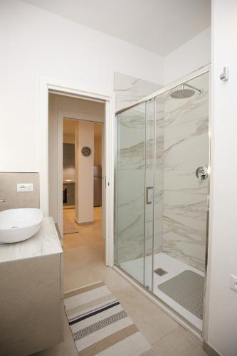 a bathroom with a glass shower and a sink at Appartamento Ralf - In Centro in Castelsardo