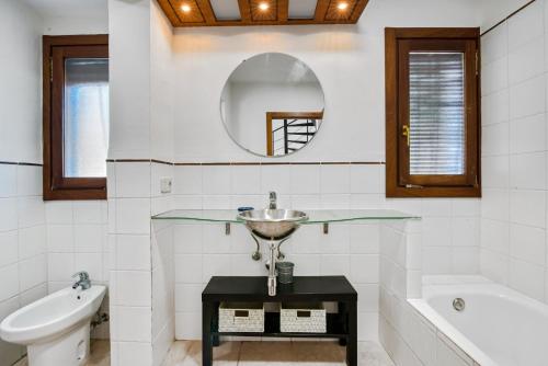 a bathroom with a sink and a tub and a mirror at Araucaria in Denia