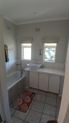 a bathroom with a tub and two sinks and a bath tub at Maselli Guesthouse in Howick