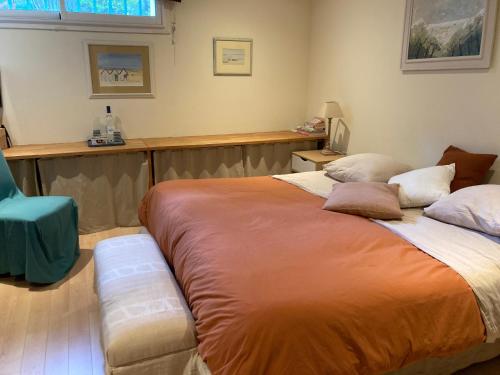 a bedroom with a large bed and a blue chair at Chambre d'hotes La Rambleur in La Teste-de-Buch