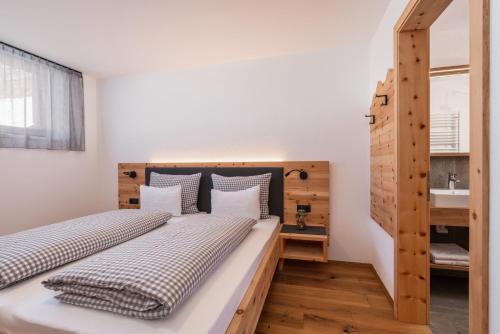 two twin beds in a room with a sink at Huberhof Gais in Gais