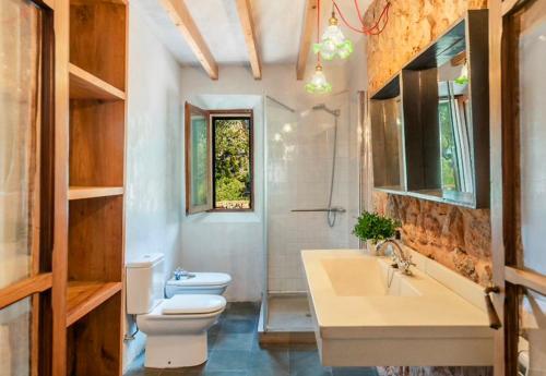 a bathroom with a toilet and a sink at Sóller Es Cocó in La Figuera