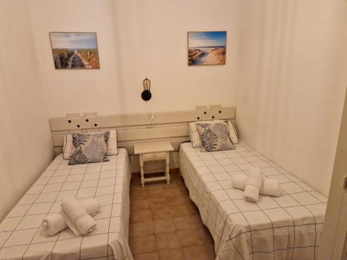 a room with two beds and a desk in it at Casita in Illes Balears
