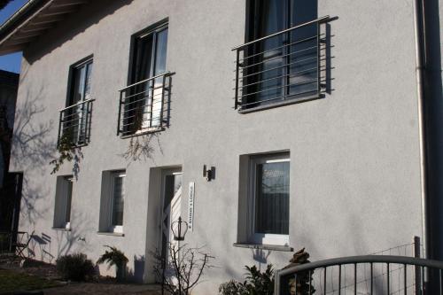 a white building with black shutters on it at Grimm's Lodge in Lörrach