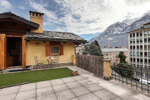 a house with a balcony with a table and chairs at La Mansardina - Aosta in Aosta