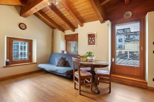 a living room with a table and a couch at La Mansardina - Aosta in Aosta
