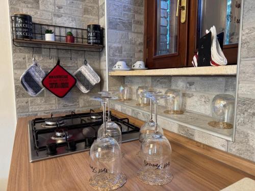 a kitchen with a stove and two wine glasses on a counter at Genghetta in Rivotorto
