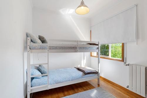 a bedroom with two bunk beds and a window at Archer'shouse - Olival's Treasure in Olival