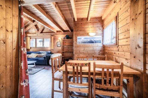a dining room with a table and chairs in a log cabin at Chalet 6p Classique - Les Gentianes in Verchaix