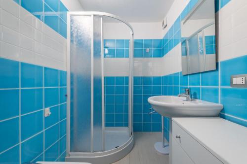 a blue bathroom with a sink and a shower at Villa Simonetta n9 in Costa Rei