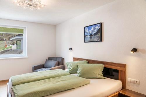 a bedroom with a bed and a chair at Haus Florian Ski-in and Ski-out in See