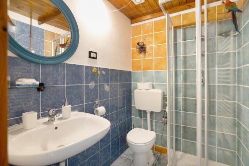ein Badezimmer mit Waschbecken, Toilette und Spiegel in der Unterkunft Acciuga House in Biassa
