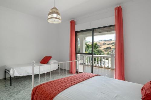 a bedroom with two beds and a large window at Casa El Molino in Montecorto