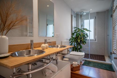a bathroom with two sinks and a toilet at 'Salmosalar' Cangas de Onís in Cangas de Onís