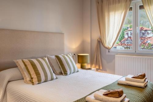 a bedroom with a white bed with towels on it at 'Salmosalar' Cangas de Onís in Cangas de Onís