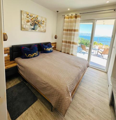 a bedroom with a bed with a view of the ocean at Villa Jasmina in Stomorska