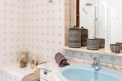 a bathroom with a blue sink and blue and white tiles at Art Gallery House in La Cala de Mijas