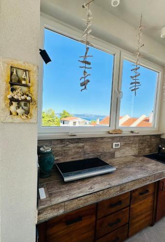 a kitchen with a window with a laptop on a counter at Villa Jasmina in Stomorska