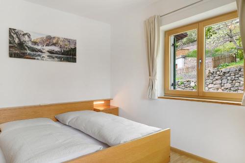 a bedroom with a bed and a window at Unterzerunhof 2 in Laion