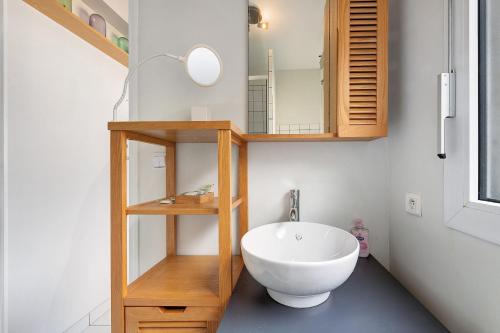 a bathroom with a white sink and a mirror at Joli appartement quartier artistes in Camaret-sur-Mer