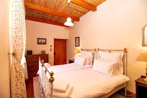 a bedroom with two beds with white pillows at De Kothuize 166 in Graaff-Reinet